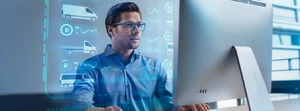 Mann mit Brille sitzt vor seinem PC
