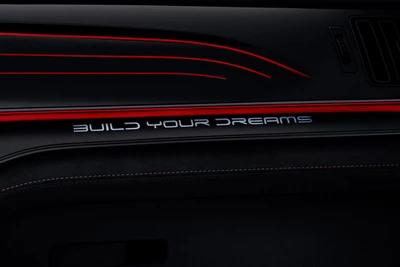 Detailaufnahme des ausgeschriebenen "BUILD YOUR DREAMS" Schriftzuges im Innenraum des BYD TANG.
